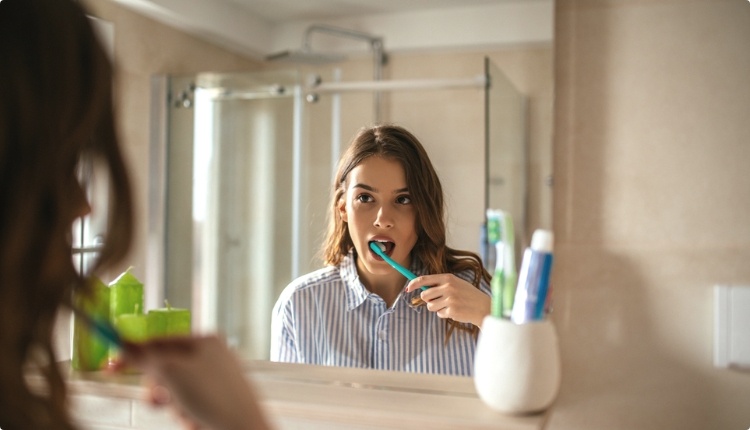 brushing teeth in mirror